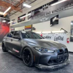 BMW M3 Competition undergoing full satin black PPF wrap installation with Inozetek film at DWraps & Tint in Ventura County.